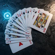 Aufgef&auml;cherte Spielkarten auf nasser reflektierender Oberfl&auml;che mit Neon-Reflexionen - Casea Casino vierte Einzahlung